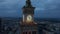 Fly around Tower clock. Large illuminated clock face and lookout terrace above city in twilight time. Warsaw, Poland
