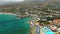 Fly away from Hersonissos, aerial view on blue sea, boats and town houses