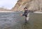 Fly fisherman casting for trout on a river