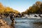 Fly fisherman catching a fish in the mountain river.