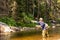 Fly fisherman fishing fresh water mountain stream for river trout