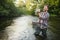 Fly-fisherman holding trout out of the water