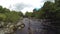 A fly fisherman hooking and fighting a fish, while salmon fishing on a river