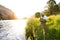 Fly fisherman on the river bank at sunrise