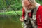 Fly fishing angler makes cast while standing in water