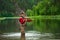 Fly fishing angler makes cast while standing in water