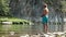 Fly fishing. An elderly fisherman stands knee-deep in the water of a mountain river. A bare man in blue shorts on the