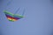 Fly Kite in Sky. Rainbow kite on blue background