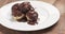 Fly out shot of profiteroles with fine dark chocolate on plate