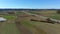 Fly over autobahn near forest with town on horizon.Aerial video of autobahn through green meadow and forest