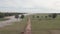 Fly over a muddy path and horses grazing through flooded field