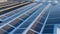 Fly over Solar cells on the roof of a large industrial factory. Solar roofs are generating renewable energy for the industry. The