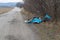 Fly tipped rubbish dumped in a lay-by in a country lane. Heap of illegally dumped household rubbish left on a side of the road