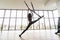 Fly yoga in a white gym. Young woman make fly yoga Gymnastics performs physical exercises in yoga studio