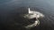 Flyboard instructor is flying up and down, performing flip on lake, aerial view on sportsmen in summer day