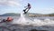 Flyboarding is a new extreme water sport. Athletic man performs tricks in flight. Spectacular sports coups and turns.