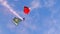 Flyby of military paratroopers with red and white canopy and smoke from behind