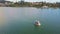 Flycam shows people on swan catamaran on flat large lake
