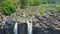 Flycam shows rocky rapids waterfalls against plants