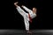 Flyer. Portrait of young girl, teen, taekwondo athlete practicing alone isolated over dark background. Concept of sport