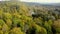 Flying above colorful autumn forest treetops on sunny day. Latvia, Turaida