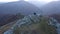 Flying above a couple relaxing on a mountain cliff. Aerial