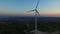 Flying above elegant white windmill at sunset