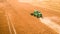 Flying above green harvester harvesting seed in Poland