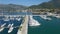 Flying above luxury marina pier with white yachts