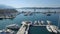 Flying above luxury marina pier with white yachts and sailing boats