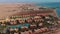 Flying from above over the hotel and the desert near Hurghada. Top view of residential buildings, swimming pools for tourists.