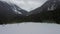 Flying above snowy forest lake