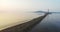 Flying above spit. Aerial view of the running sportsman and lighthouse. Morning