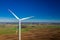 Flying above white wind turbines in a field in Poland