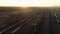 Flying aerial view over a railway sorting station at sunset. Many wagons and railway tracks at an industrial freight