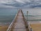 flying along a wooden deserted pier extending into the sea