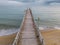 flying along a wooden deserted pier extending into the sea