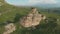 Flying around a large rock formation standing at the foot of the epic edge of a rocky plateau. Russia. North Caucasus