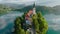 Flying around small island on Bled Lake in Slovenia. Aerial view of Church of the Assumption of Mary in the center of