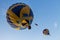Flying balloon with passengers in a basket against the blue sky at the festival of Aeronautics summer evening in Pereslavl-Zalessk