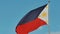 Flying bicolor flag of the Philippines with central golden sun representing the provinces and stars the islands.