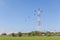 Flying birds with telecommunication tower in rural farmland, pro