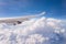 Flying into blue sky and sea of clouds and Wing of airplane with