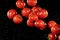 Flying cherry tomatoes, isolated on black background.