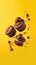 Flying chocolate cupcakes or cookies on yellow background.