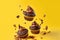 Flying chocolate cupcakes or cookies on yellow background.