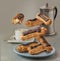 Flying  chocolate eclairs near cup with espresso and coffee pot