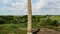 Flying close to a old brick chimney in the middle of the field