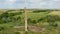 Flying close to a old brick chimney in the middle of the field