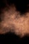 Flying cocoa powder chocolate dust cloud on isolated black background copy space